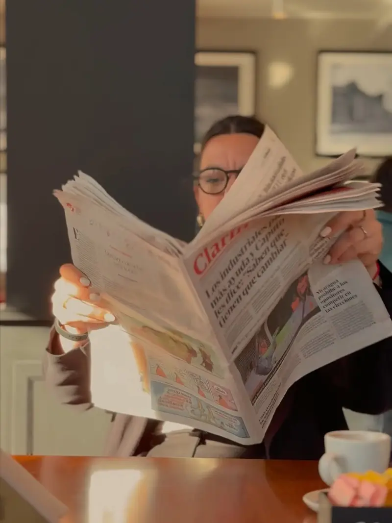 Una clienta lee el diario con su café en una mesa del Ideal