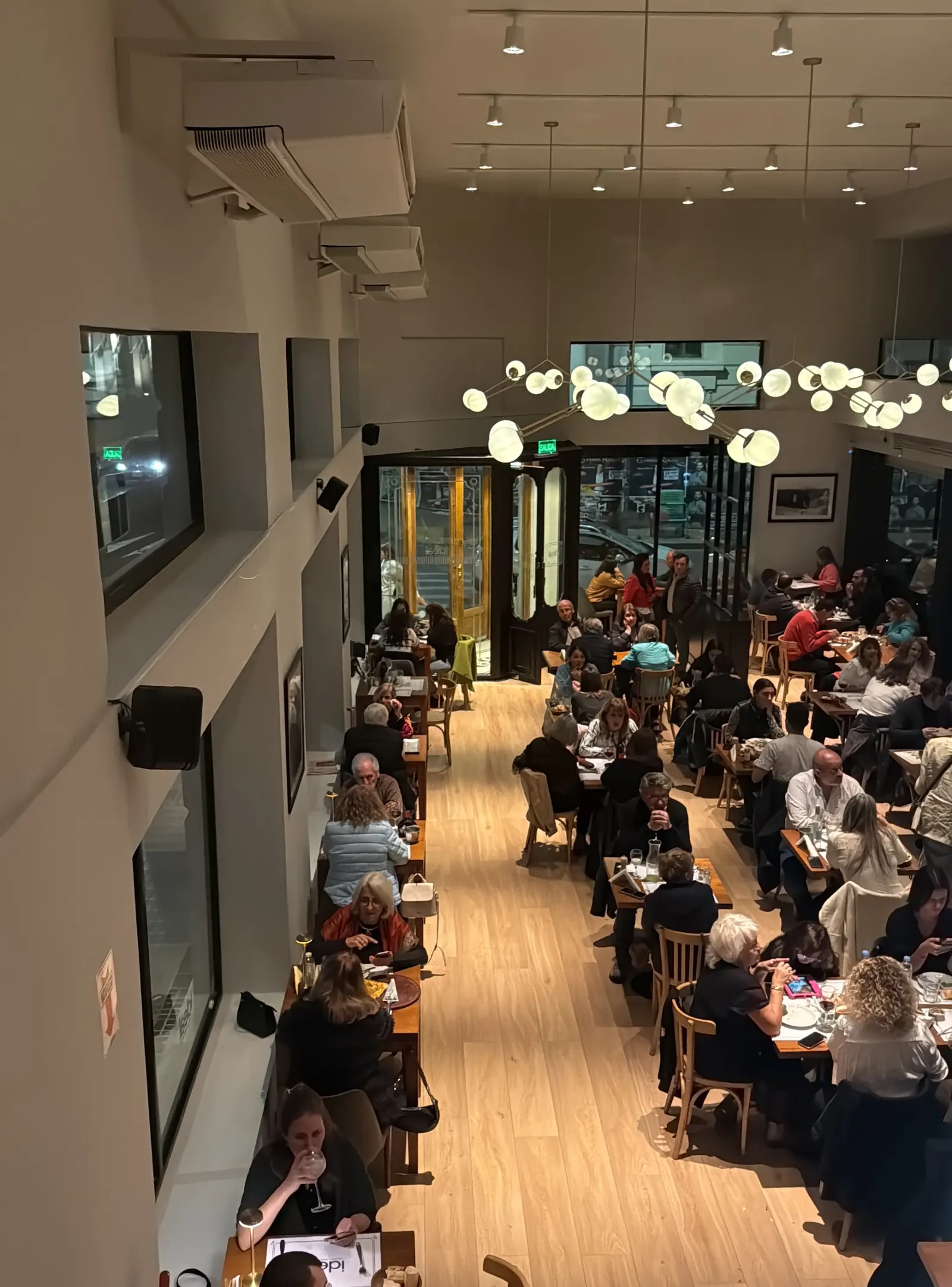 El salón del Ideal lleno de gente, con las lámparas encendidas
